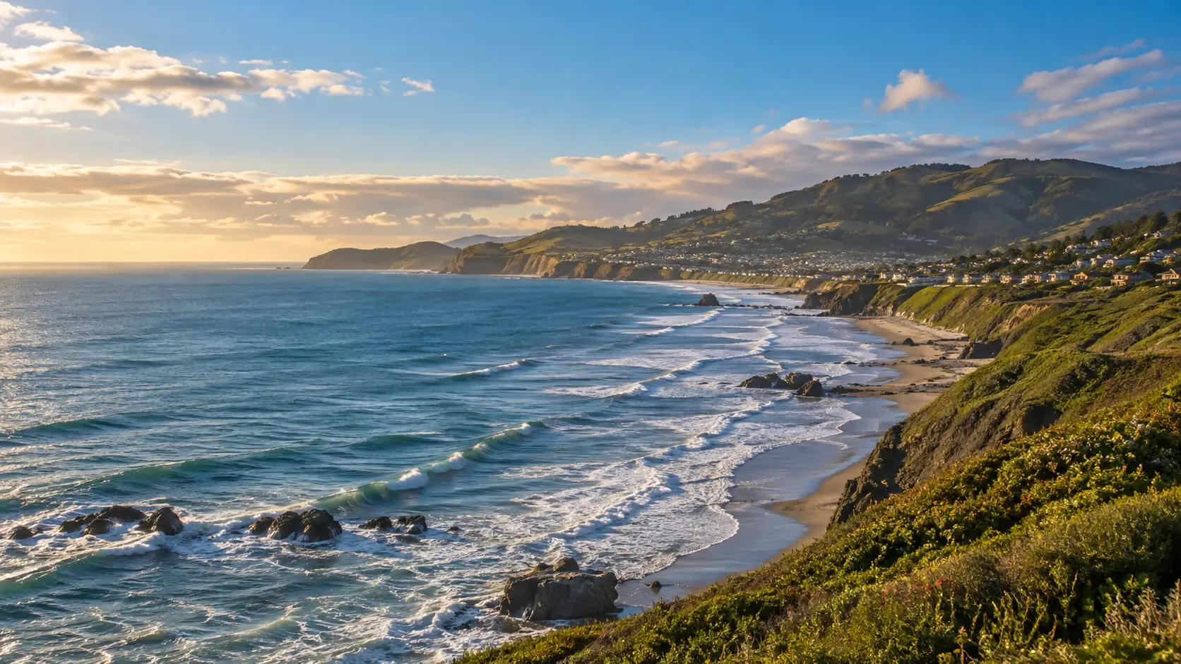 Pacifica coastline with green bluffs, ocean waves and hillside neighborhoods