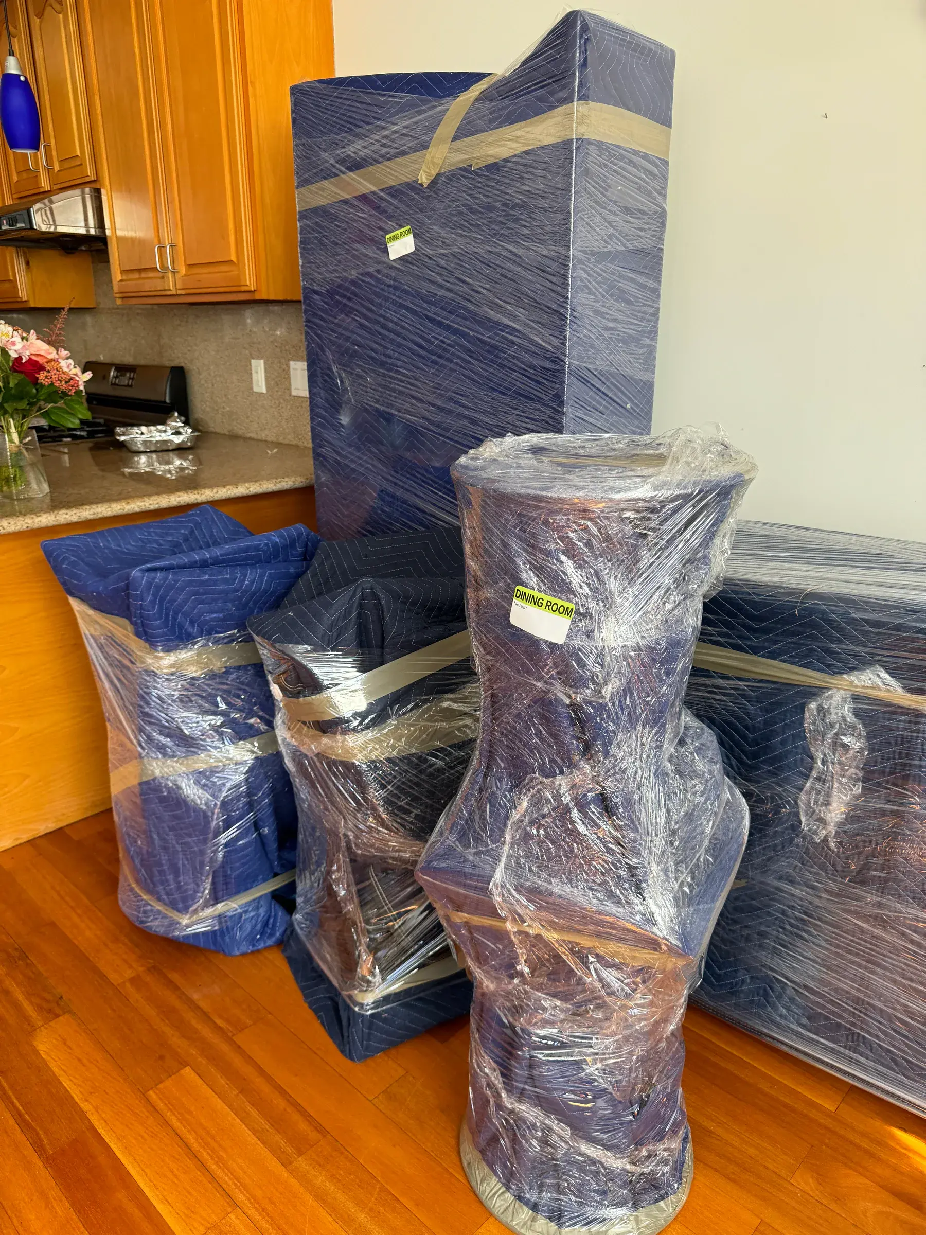 Large furniture wrapped with moving blankets inside a home