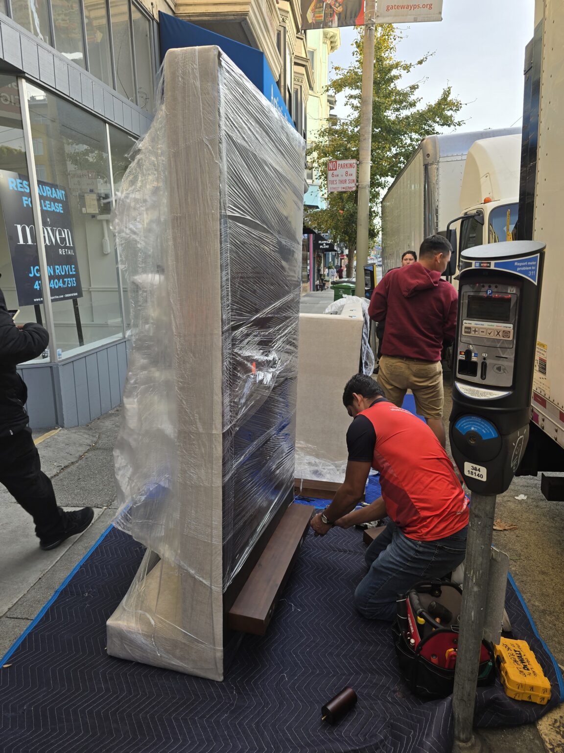 Moving crew protecting and transporting a large television in an urban area